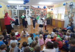 Dzieci tańczą z pomponami razem z prowadzącą audycję.